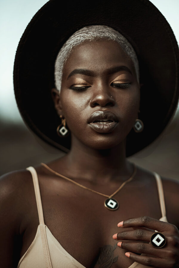 Model wearing square ring, pendant and earrings